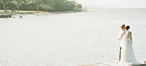 A married couple standing on a pier on holiday